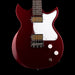 Red electric guitar with a white pickguard on a black background