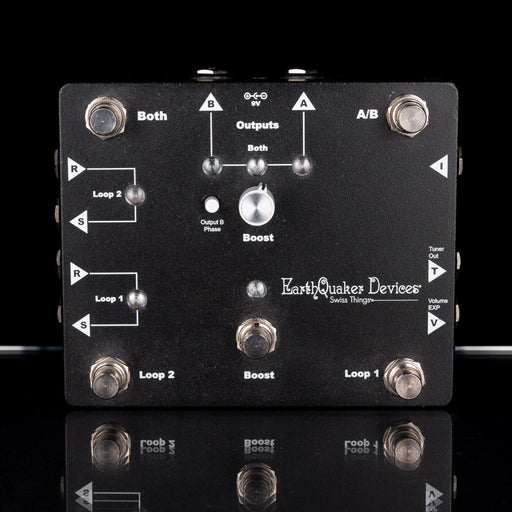 Black electronic pedal with labeled components on a black background