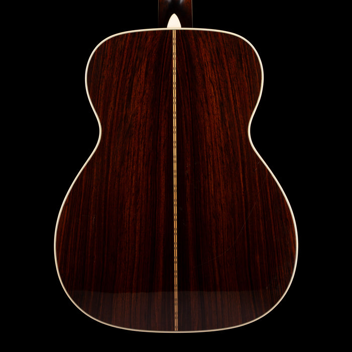 Back view of a wooden acoustic guitar on a black background