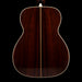 Back view of a wooden acoustic guitar on a black background