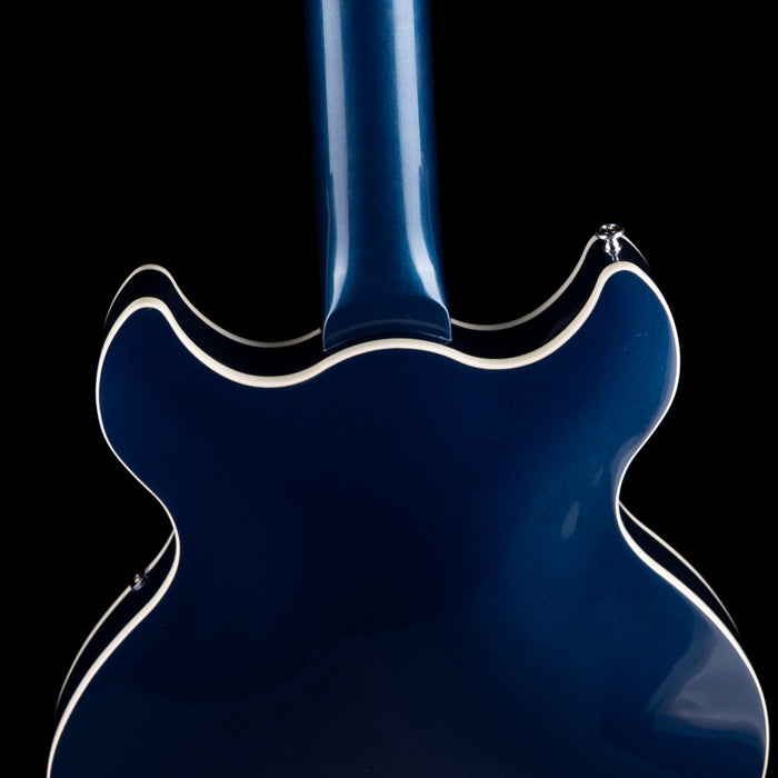 Close-up of a blue electric guitar body on a black background