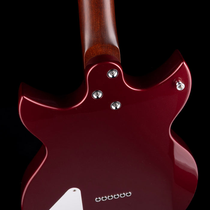 Close-up of a red electric guitar with a dark background