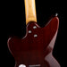 Close-up of a guitar's neck and headstock on a black background