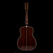 Wooden acoustic guitar on a stand with a black background