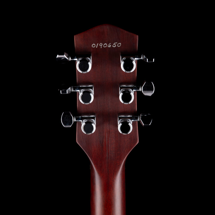 Close-up of a guitar headstock with tuning pegs on a black background