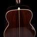 Close-up of a wooden acoustic guitar's soundhole on a black background