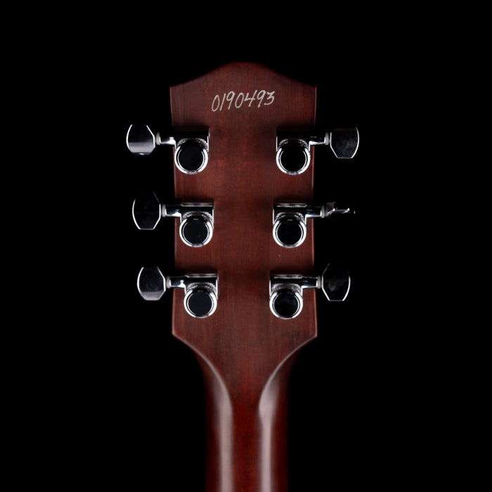 Close-up of a guitar headstock with tuning pegs on a black background