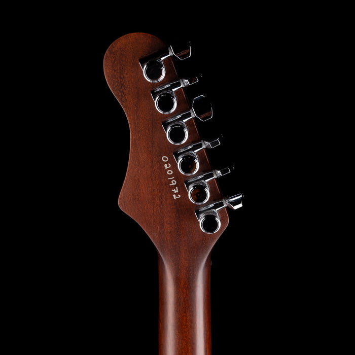Close-up of a guitar headstock with tuning pegs on a black background
