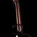 Close-up of a guitar neck with a dark finish on a black background