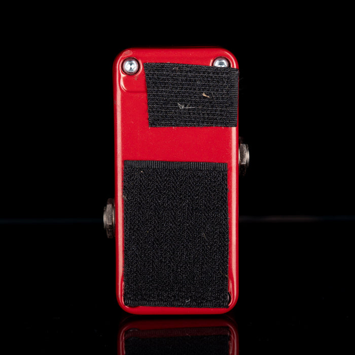 Red and black guitar effects pedal on a black background