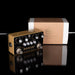 Booster guitar pedal with packaging on a reflective surface