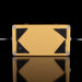 Gold and black rectangular object with textured sides on a reflective surface