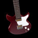 Red electric guitar with a white pickguard on a black background
