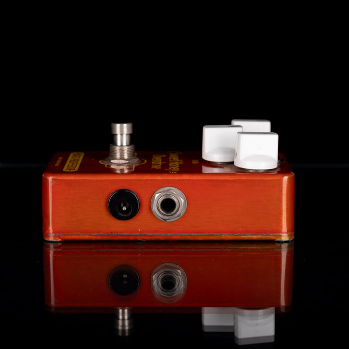 Guitar effects pedal with wooden finish on a black background