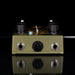 Guitar effects pedal with knobs and jacks on a reflective surface