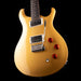 Beige electric guitar with red control knobs on a black background