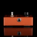 Brown guitar effects pedal with knobs on a black background