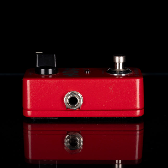 Red guitar effects pedal with two knobs on a black background