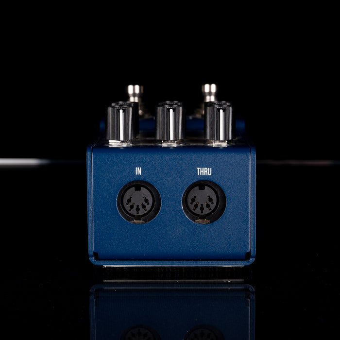 Blue audio interface with 'IN' and 'THRU' labels on a black background