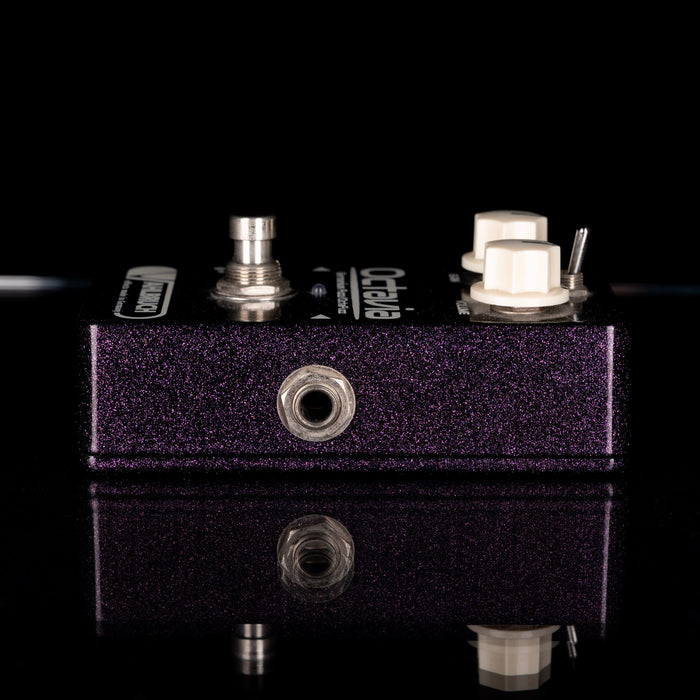 Guitar effects pedal with visible brand name on a reflective surface
