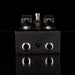 Black electronic device with metallic knobs and connectors on a black background