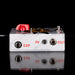 Guitar effects pedal with a red knob and labeled ports on a black background