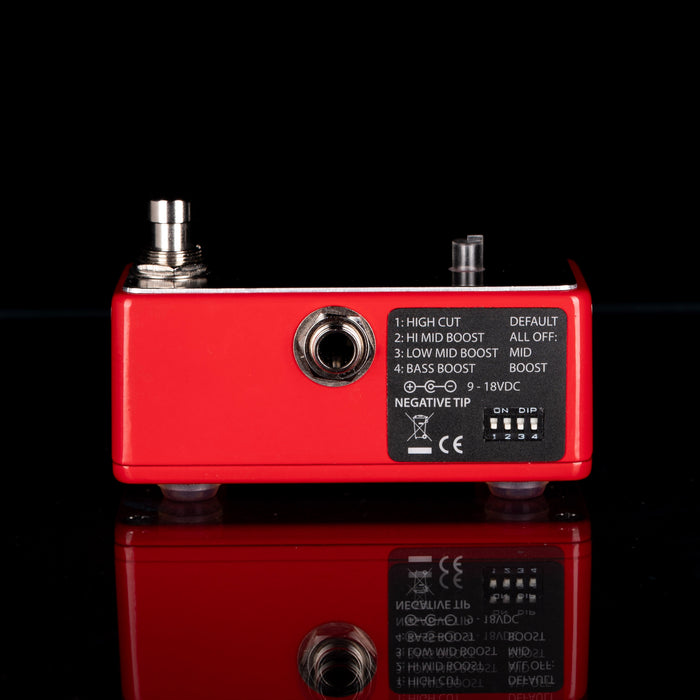 Red guitar effects pedal with control knobs and switches on a black background