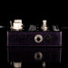 Close-up of a guitar effects pedal with visible branding on a black background