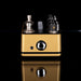 Gold and black guitar effects pedal on a reflective surface with a black background