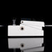 Metallic guitar effects pedal on a reflective surface with a black background