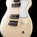 Close-up of a cream-colored electric guitar with a black pickguard on a black background
