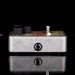 Guitar effects pedal with visible brand logo on a reflective surface