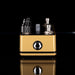 Gold and black electronic device with multiple components on a reflective surface.