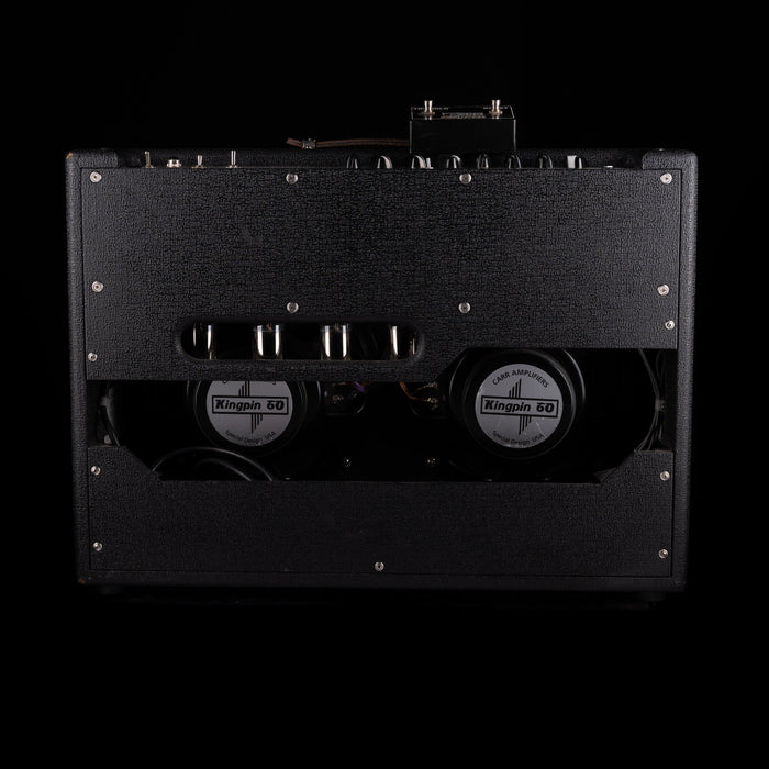 Black guitar amplifier with visible brand logos on a black background