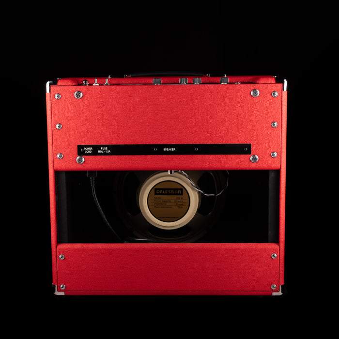 Red speaker cabinet with visible brand logo on a black background