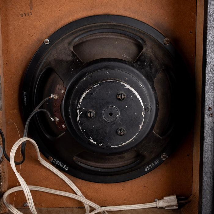 Vintage speaker with visible wiring inside a wooden cabinet