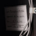 Label with handwritten text on a dark background
